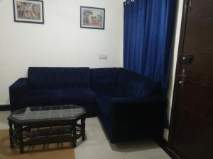 a living room with a blue couch and a table at Two Bedrooms Apartment Near DHA & Airport in Lahore