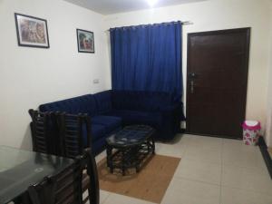 sala de estar con sofá azul y mesa en Two Bedrooms Apartment Near DHA & Airport en Lahore
