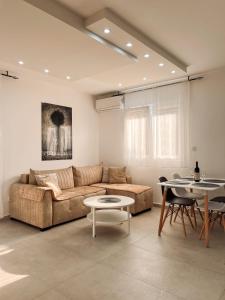ein Wohnzimmer mit einem Sofa und einem Tisch in der Unterkunft M&N Residence Tivat in Tivat