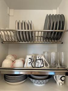a shelf with plates and utensils in a kitchen at Summer Sea Verde Blu Apt in Corfu Town +10 photos