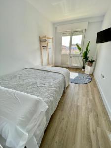 - une chambre avec 2 lits et du parquet dans l'établissement Apartamento en el corazón de Cantabria, à Torrelavega