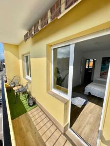 Cette chambre dispose d'un balcon avec un lit et une fenêtre. dans l'établissement Apartamento en el corazón de Cantabria, à Torrelavega