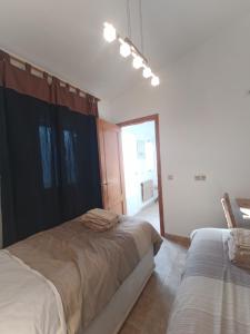 a white room with two beds and a window at Bonita Casita Luz del Sol in Arboleas