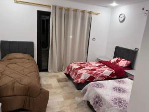 a bedroom with two beds and a chair in it at Giving Paradise Chalet in Amman
