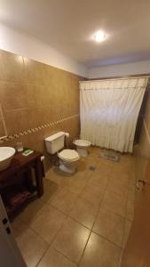 a bathroom with two toilets and two sinks at Cabañas Las Primorosas in Cañuelas