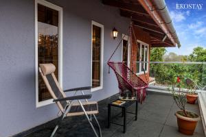 um alpendre com uma cadeira de baloiço e uma janela em EKOSTAY - Oslo Villa em Wada