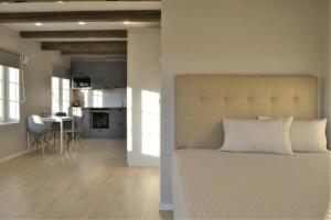 a white bedroom with a large bed and a kitchen at JAKOBSON HOUSE in Rapla