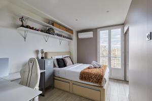 Habitación pequeña con cama y ventana en Appartement Rolland Garros, Parc des Princes by Studio prestige, en Boulogne-Billancourt