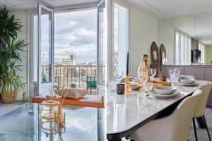 comedor con mesa y ventana grande en Appartement Rolland Garros, Parc des Princes by Studio prestige, en Boulogne-Billancourt