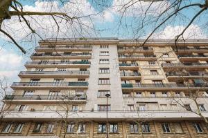 un edificio alto con muchas ventanas. en Appartement Rolland Garros, Parc des Princes by Studio prestige, en Boulogne-Billancourt