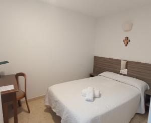 a room with a bed with a towel on it at Hospedería Santa María do Mar in Sanxenxo