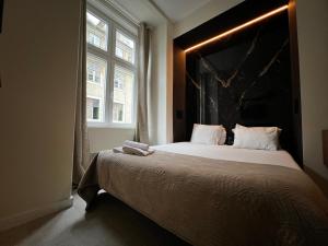 ein Schlafzimmer mit einem großen Bett und einem großen Fenster in der Unterkunft Lisbon Studios in Lissabon