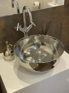 a bathroom sink with a large silver bowl at Ferienhaus unter Reet im Heidedorf Sankt Dionys bei Lüneburg in Sankt Dionys +60 photos