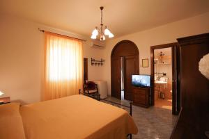 a bedroom with a bed and a flat screen tv at Salento Terra Maris in Cocumola
