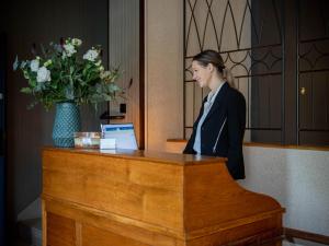 une femme debout sur un bureau avec un ordinateur portable dans l'établissement Relais de la Loire, à Montlivault