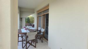 a dining room with a table and chairs on a balcony at Garden Oasis Elegant Summer House in Kalandra