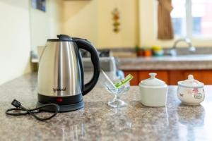 a coffee maker and glasses sitting on a kitchen counter at Tourist House Suites Otavalo in Otavalo