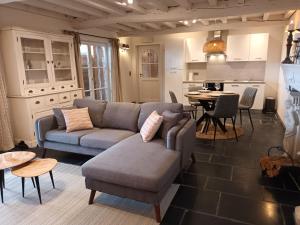 ein Wohnzimmer mit Sofa und Tisch in der Unterkunft DE LANDSHOEVE vakantiewoningen in Zwalm