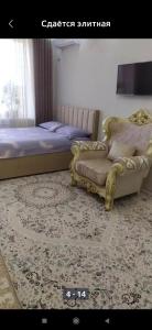 a bedroom with a bed and a couch and a rug at 1 комнатная квартира in Bishkek