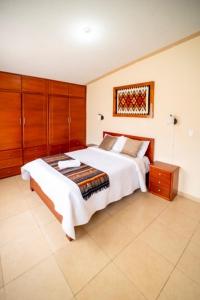 a bedroom with a large bed and wooden cabinets at tourist house suites 2 in Otavalo