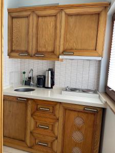 a kitchen with wooden cabinets and a sink at Veziroğlu Apart in Datca