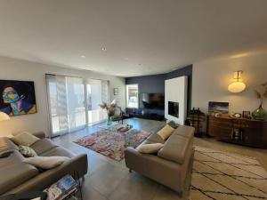 a living room with two couches and a television at Belle villa, piscine et cigales au calme ! in Saint-Jean-de-Védas