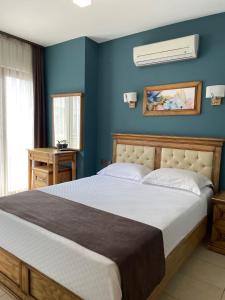 a bedroom with a large bed with blue walls at Veziroğlu Apart in Datca