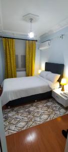1 dormitorio con 1 cama grande y cortinas amarillas en Bahcelievler Memorial Hospital Suit, en Estambul