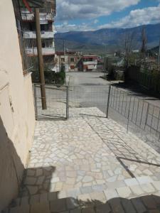 a fence on a sidewalk next to a street at Ledion Apartment in Gjirokastër