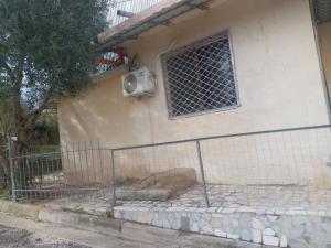 a building with a fence next to a window at Ledion Apartment in Gjirokastër +1 photo