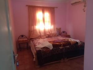 - une petite chambre avec un lit et une fenêtre dans l'établissement auberge djebel rose, à Tafraout