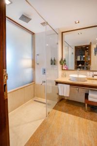 W łazience znajduje się szklana kabina prysznicowa i umywalka. w obiekcie Royal Orchid Central Jaipur, Bani Park w mieście Dżajpur