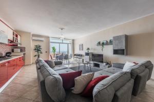 a living room with a large couch and a kitchen at Three Bedroom Romantic Promenade Apartment in Durrës