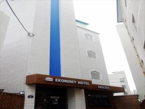 龜尾的住宿－Ekonomy Hotel，酒店前方有蓝色杆的建筑