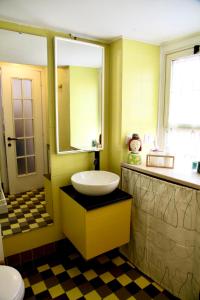 ローマにあるCasa Vacanza Marruciniの黄色のバスルーム(シンク、鏡付)