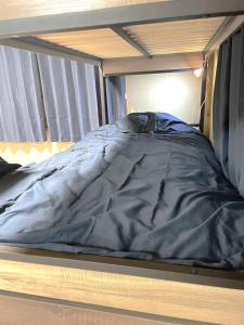 a bed with a black comforter on top of it at Nikko World Heritage STAY【日光山内】一棟丸貸しの宿 in Nikko