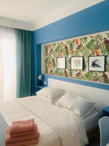 a bedroom with a large bed with blue walls at Petrus Studio with balcony in Thessaloniki