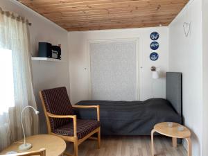ein kleines Schlafzimmer mit einem Bett und einem Stuhl in der Unterkunft Naturskönt boende vid Sjö in Skånes Fagerhult