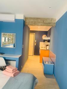 een slaapkamer met blauwe en oranje muren en een bed bij Petrus Studio with balcony in Thessaloniki