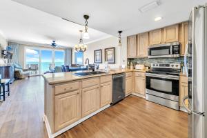 a kitchen with wooden cabinets and a view of the ocean at Grandview East 702 in Panama City Beach