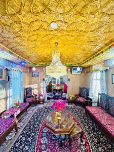 Houseboat Newworld and transportation في سريناغار: غرفة معيشة بأثاث وردي وسقف ذهبي