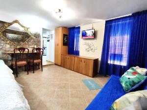 una camera da letto con tende blu, un divano blu e un tavolo di Naupactus unique harbor apartment in a stone house! a Nafpaktos