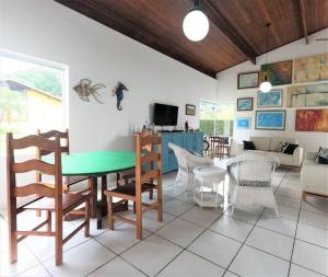 ein Wohnzimmer mit einem grünen Tisch und Stühlen in der Unterkunft Casa com piscina a 250m da praia! in Ubatuba