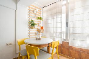 聖波拉的住宿－Casita del Puerto 1，一间小餐厅,配有桌子和黄色椅子