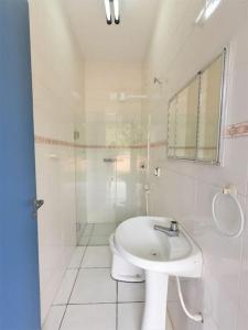 ein weißes Bad mit einem Waschbecken und einem WC in der Unterkunft Casa com piscina a 250m da praia! in Ubatuba