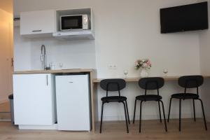 a kitchen with a counter with stools and a microwave at LP - 4 saisons in Annecy