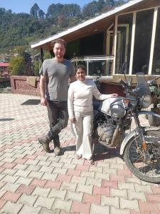 un hombre y una mujer de pie junto a una motocicleta en Da Shack en Mandi