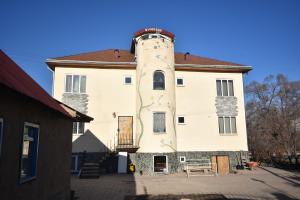 a building with a tower with a bench in front of it at Riverside Karakol in Karakol