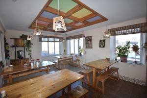 a dining room with wooden tables and windows at Riverside Karakol in Karakol