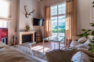 uma sala de estar com um sofá e uma mesa de vidro em Casa El Lago Alojamiento Rural em Las Jaras
